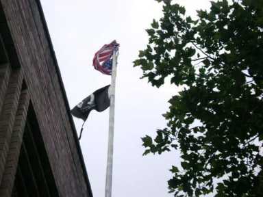 Old glory has seen better days on Avenue X – Tattered American flag flies over post office