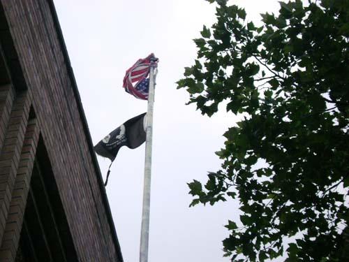 Old glory has seen better days on Avenue X – Tattered American flag flies over post office