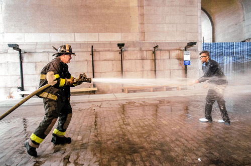 Say it and spray it: Artist endures fire-hoses’s blast for protest art