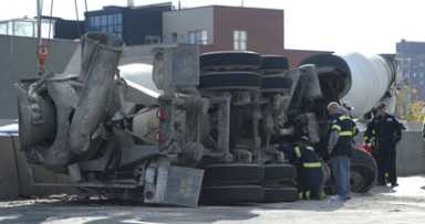 Rise of the machine! Truck helps truck as crane lifts fallen cement mixer
