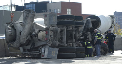 Rise of the machine! Truck helps truck as crane lifts fallen cement mixer