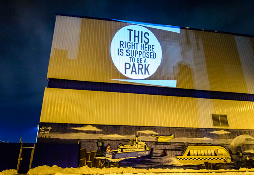 Their rage in lights! Activists illuminate building to protest city’s broken park promise