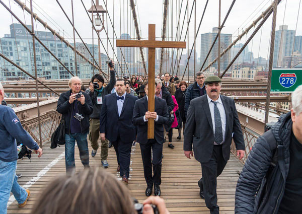 Walking the walk: Cross-bearing Catholics traverse Bklyn Bridge to honor Jesus’s journey to crucifixion