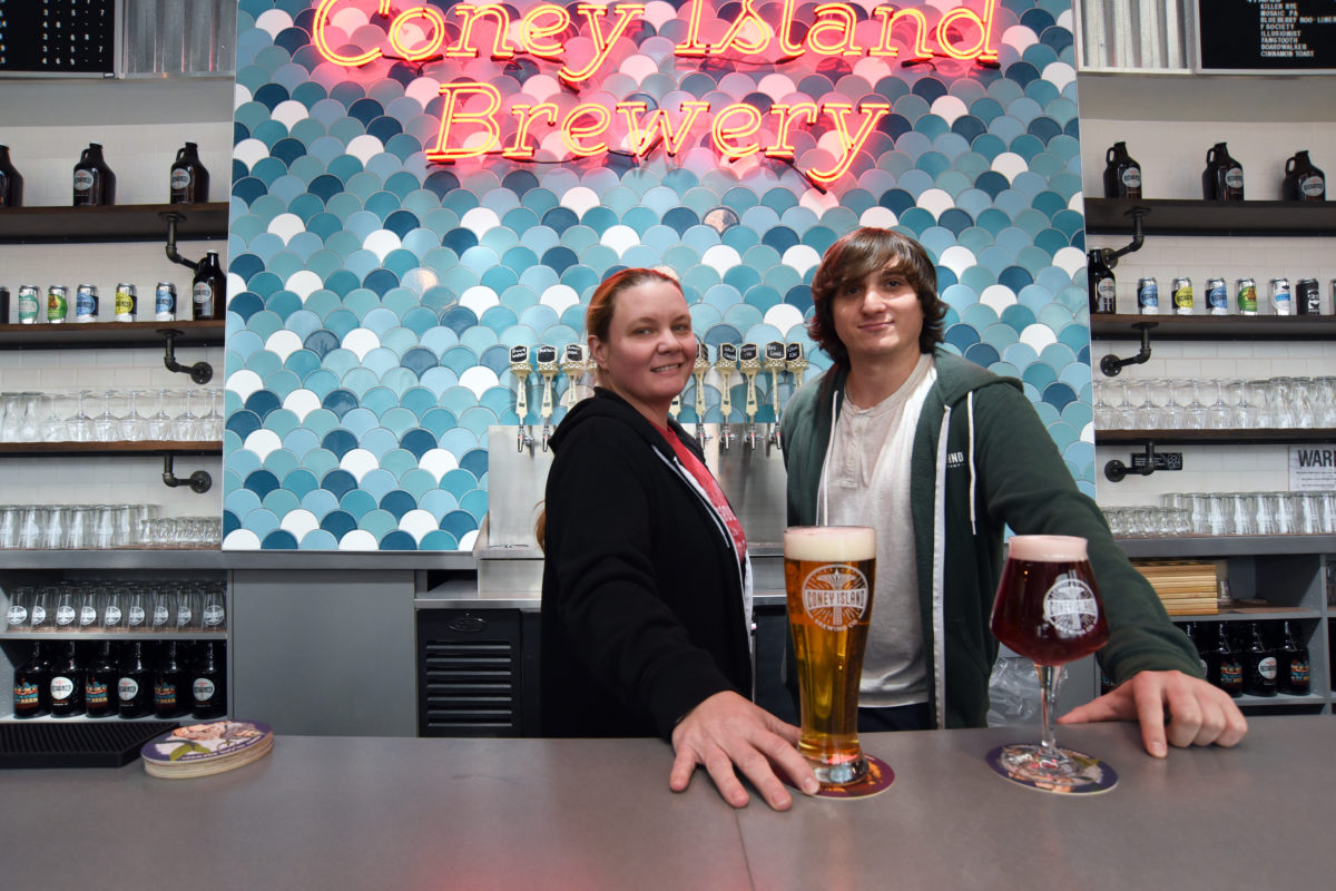 Two bartenders stand behind one of the brewery's two new bars.