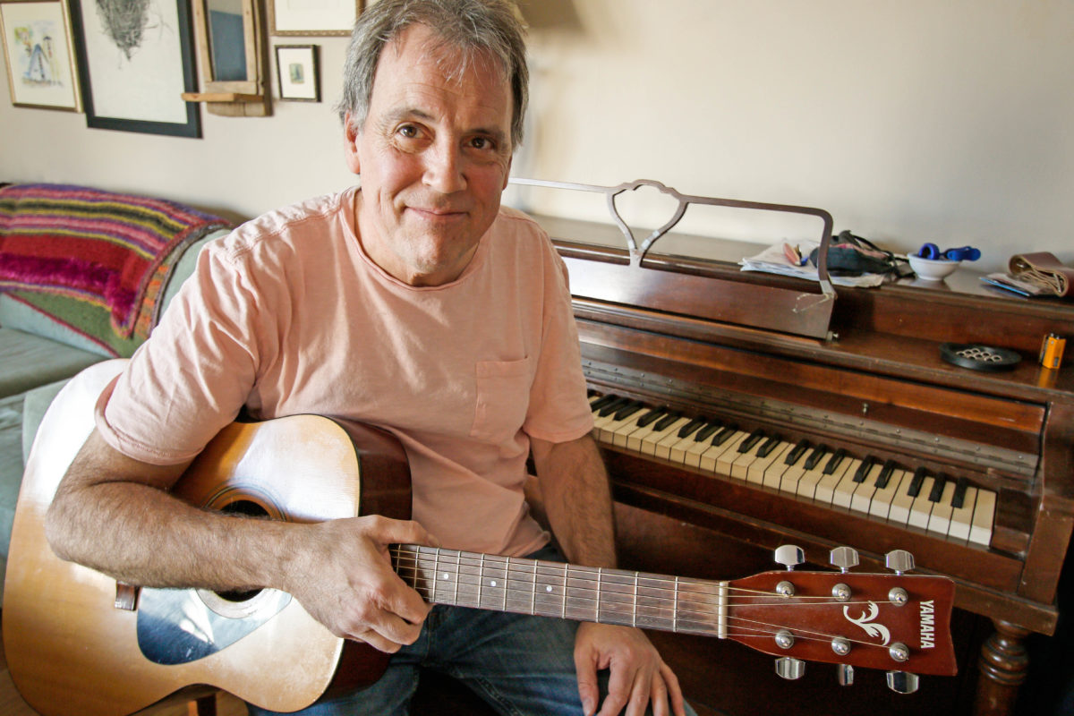 Musician David Roche poses with his guitar