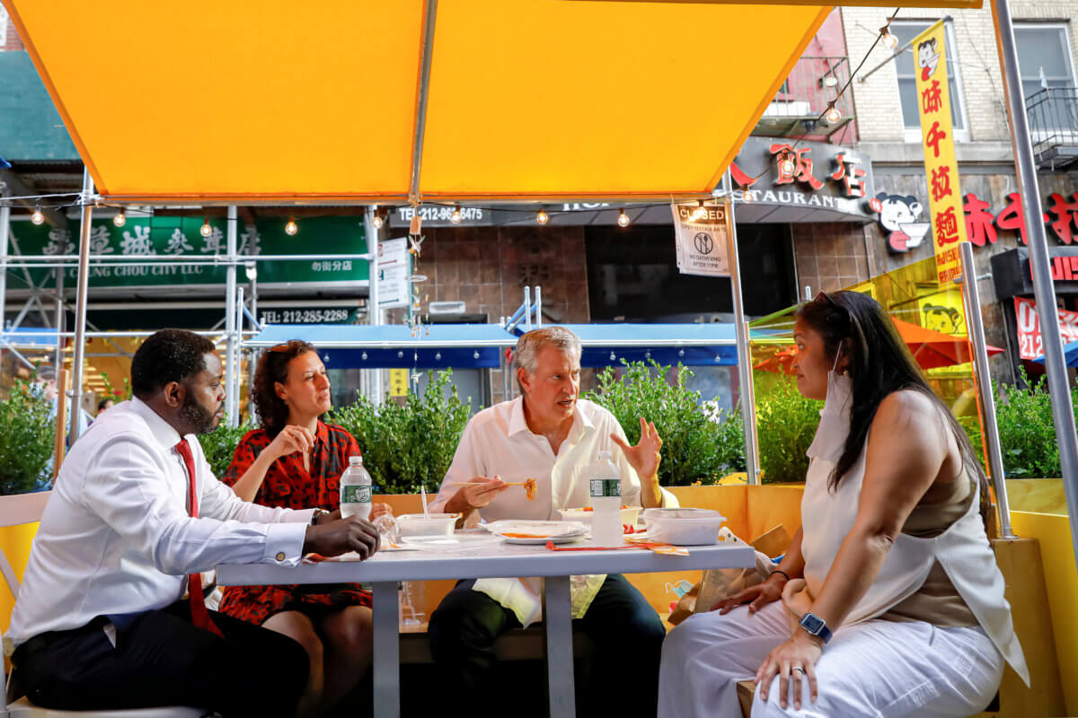FILE PHOTO: New York City Mayor Bill de Blasio eats lunch with staff members outside the Wo Hop restaurant in the Chinatown area of New York
