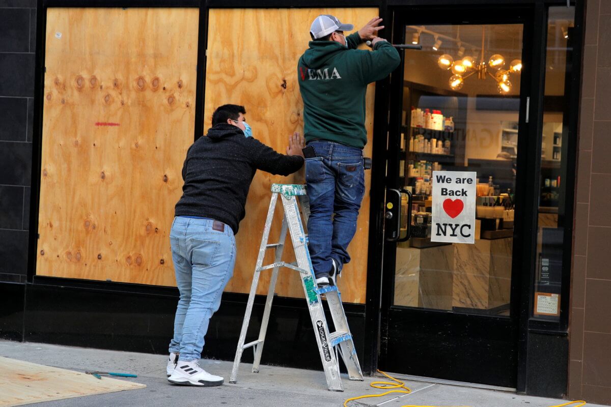 Workers board up a store ahead of election results in Manhattan, New York