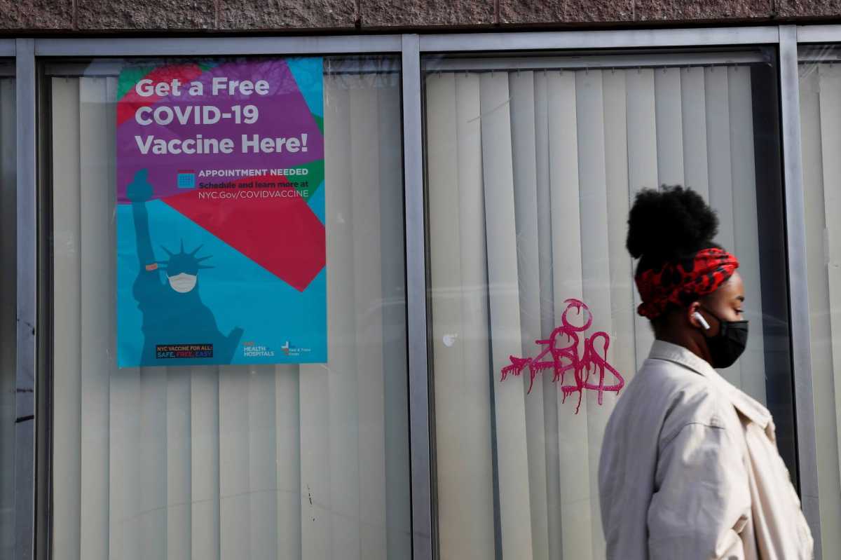 A woman walks by a NYC Vaccine Hub