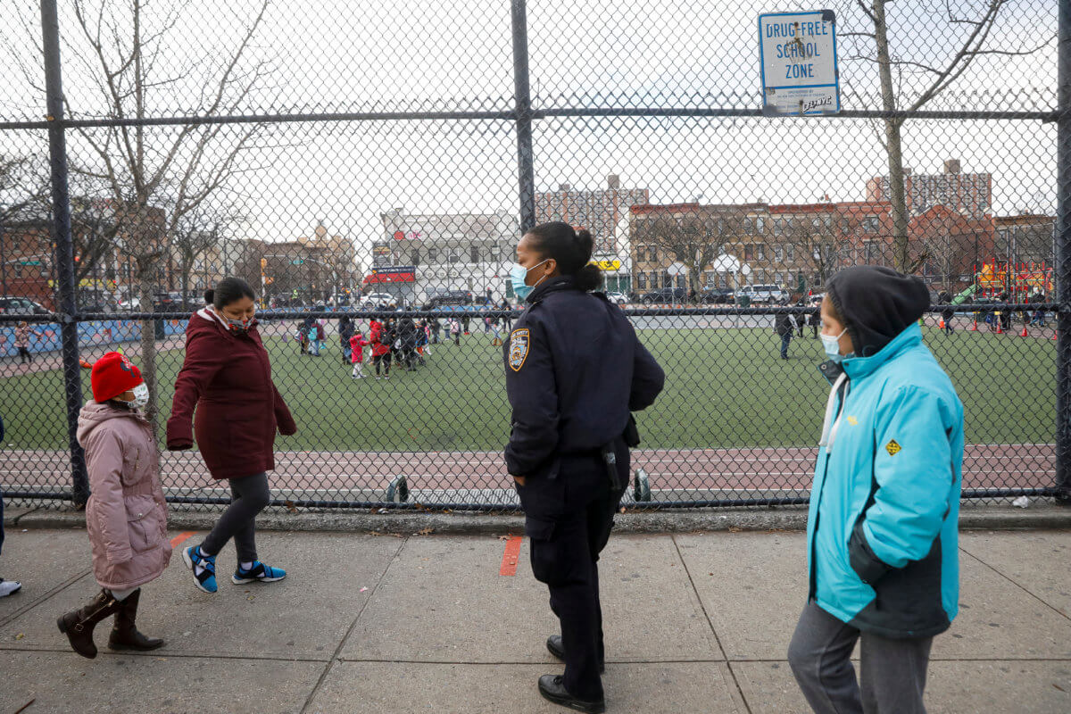 FILE PHOTO: A school safety officer greets students as they return to New York City’s public schools for in-person learning, as the global outbreak of the coronavirus disease (COVID-19) continues, at P.S. 506 in Brooklyn, New York