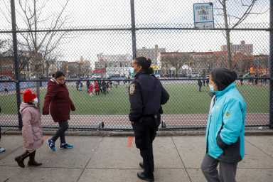FILE PHOTO: A school safety officer greets students as they return to New York City’s public schools for in-person learning, as the global outbreak of the coronavirus disease (COVID-19) continues, at P.S. 506 in Brooklyn, New York