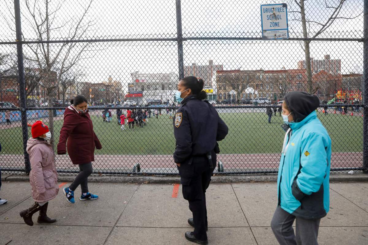 FILE PHOTO: A school safety officer greets students as they return to New York City’s public schools for in-person learning, as the global outbreak of the coronavirus disease (COVID-19) continues, at P.S. 506 in Brooklyn, New York