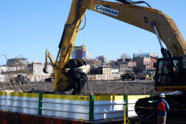 A crane scoops "black mayonnaise" out of the Gowanus Canal. Two treatment facilities, Owls Head and Head end, endeavor to keep the sludge out of the canal entirely.