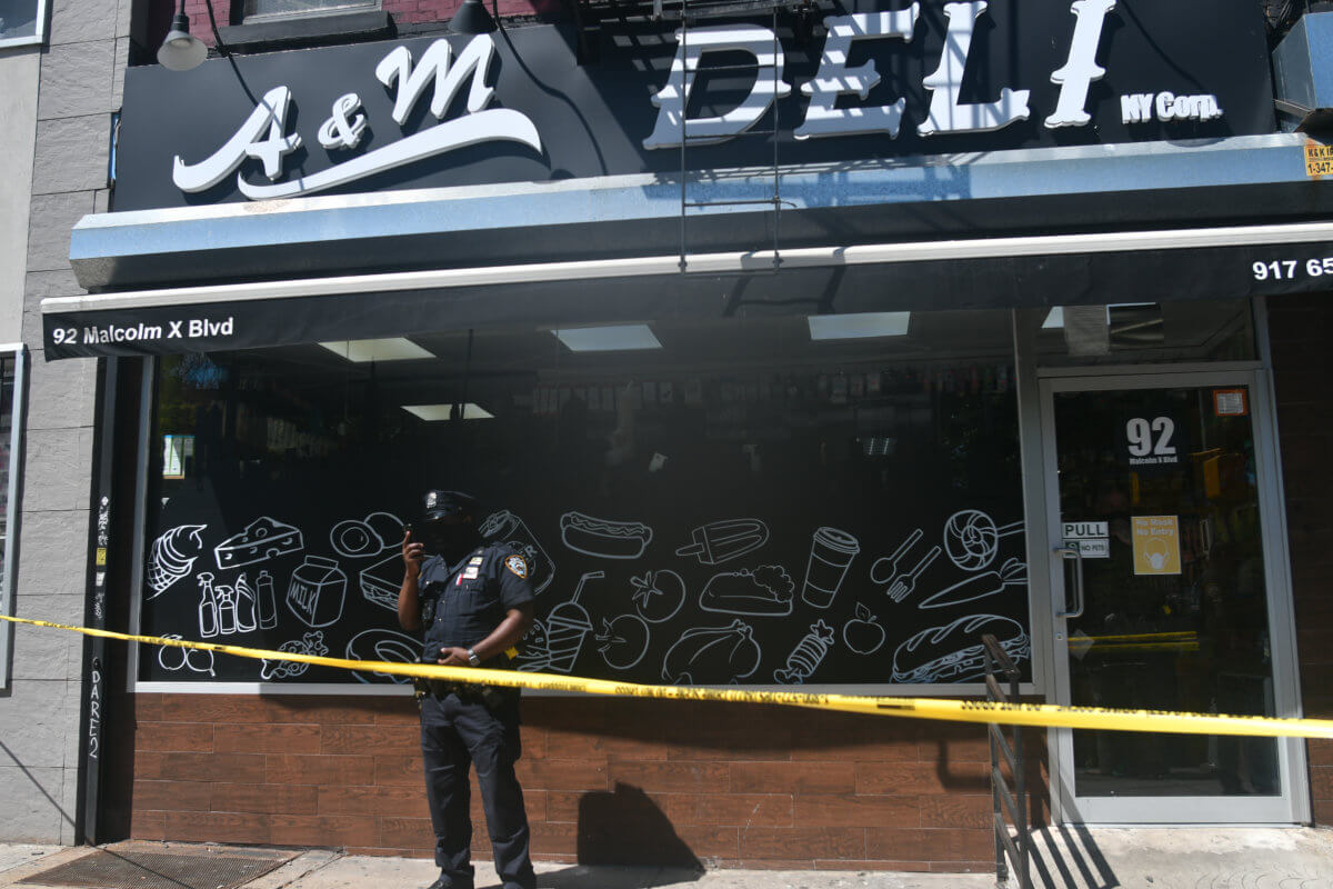 Police from the 81 Precinct probe a shooting at A&M Deli.