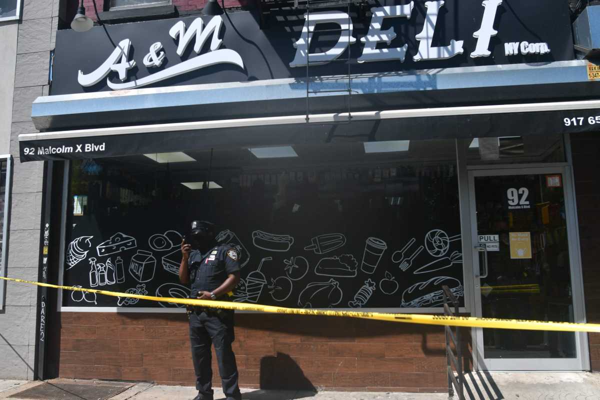 Police from the 81 Precinct probe a shooting at A&M Deli.