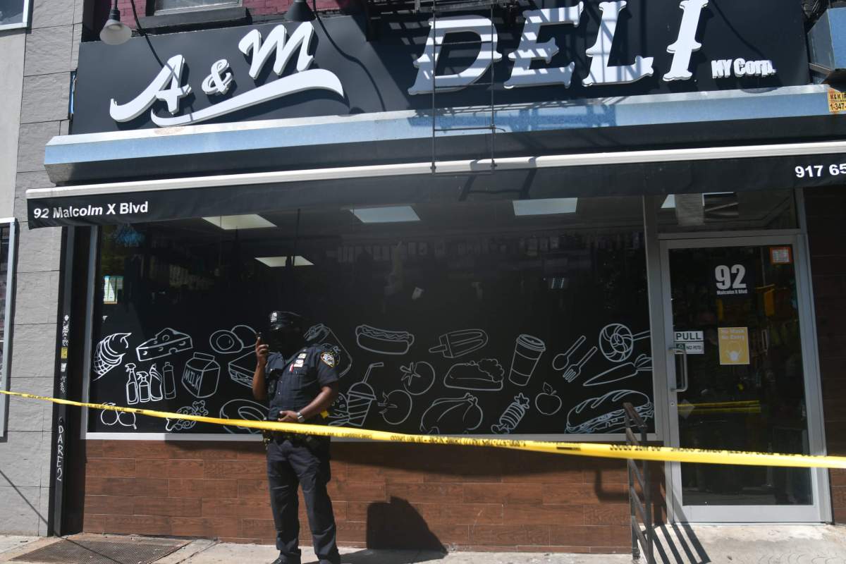 Police from the 81 Precinct probe a shooting at A&M Deli.
