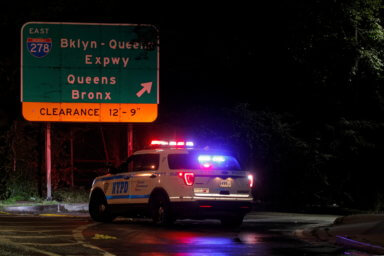 New York City Police vehicles block the entrance to the Brooklyn-Queens Expressway due to flooding in Brooklyn, New York