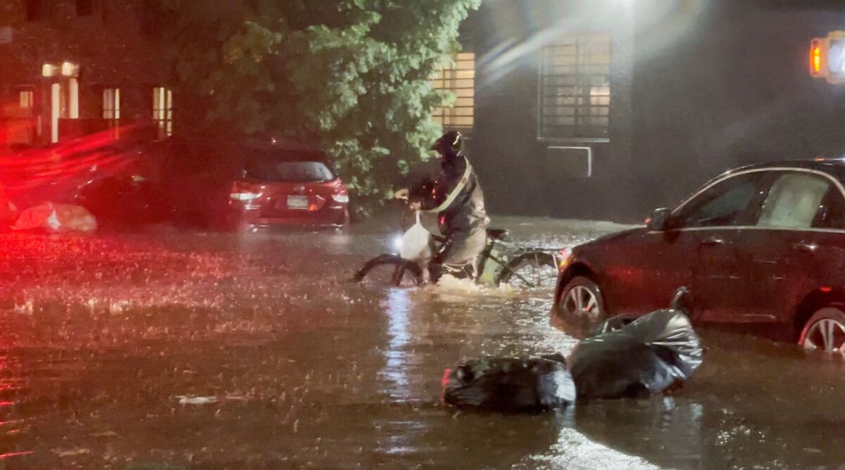 A man pushes a bicycle on a flooded street following Tropical Storm Ida in Brooklyn, New York