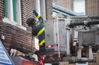 Firefighters work to open up the structure at 480 Atkins Avenue.