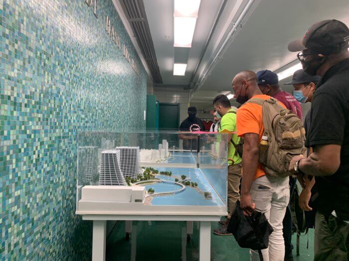 Meeting attendees look at a model of a proposed Two Trees development