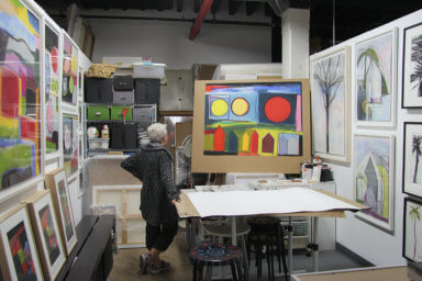 Jo Ann Acey, a Gowanus Artist, looks at paintings in her studio