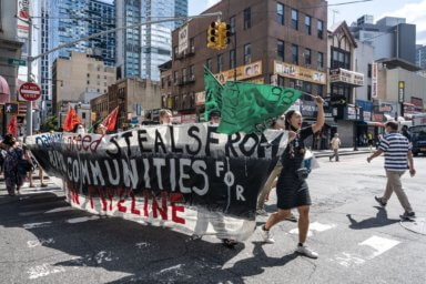 Protestors hold a banner as they fight against National Grid's sponsorship of Climate Week NYC to protest national grid