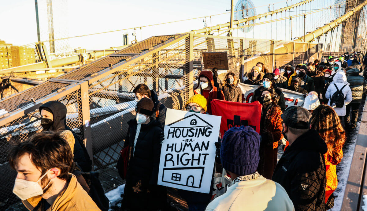 activists march against end eviction moratorium and for good cause eviction with signs on brooklyn bridge