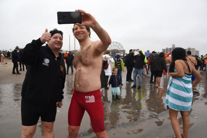people take a selfie on the beach at the coney island polar bear plunge
