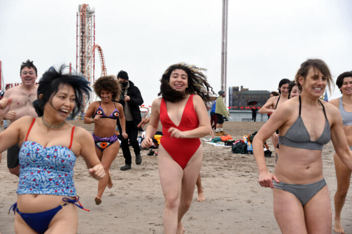 people run into the ocean at the annual polar bear plunge in coney island