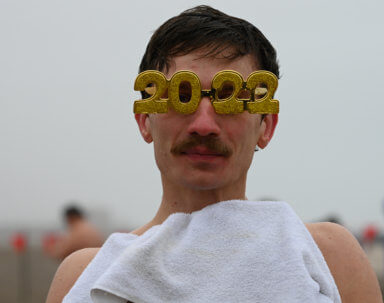 a man faces the camera in 2022 glasses at the annual polar bear plunge in coney island
