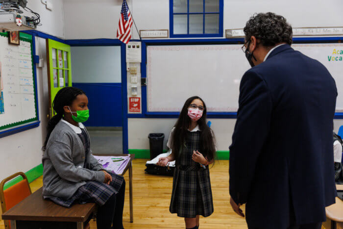 students in uniform talk to st francis president
