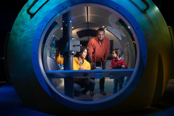 child and parents in submarine at playquarium