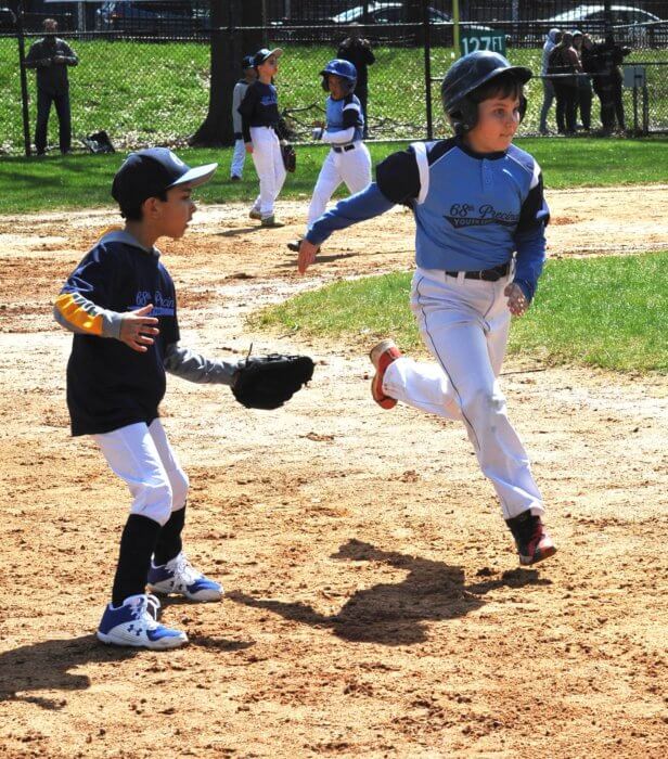 a player runs the bases at a little league game as youth sports return to Brooklyn