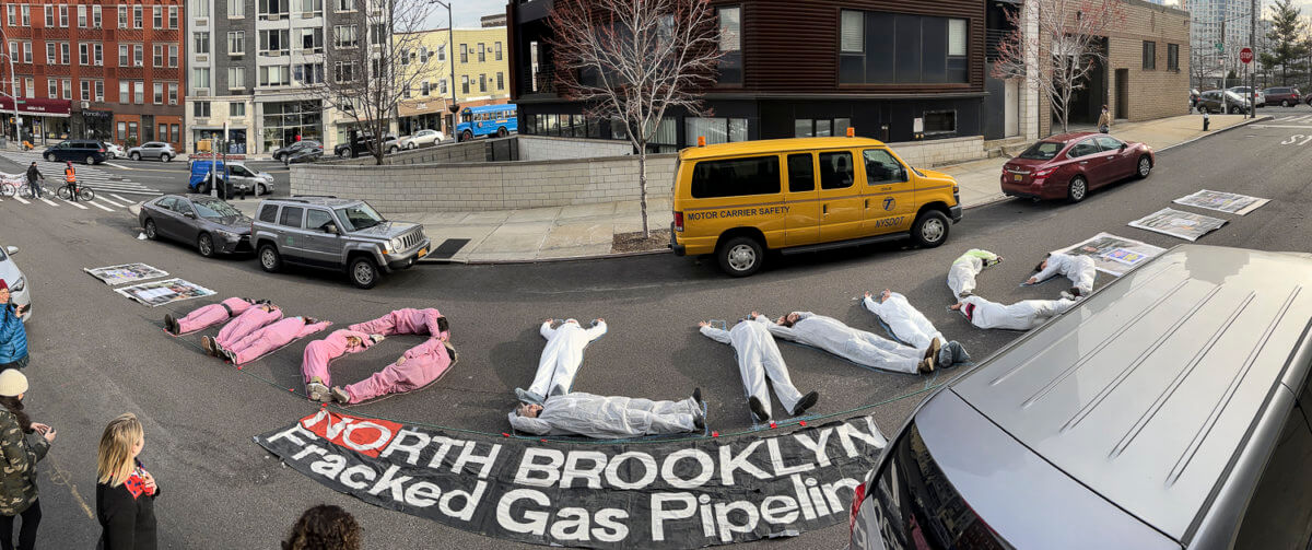 people protest national grid by laying in the street, spelling "NO LNG"