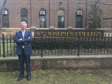 man outside st. joseph's college sign