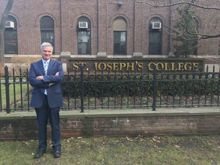 man outside st. joseph's college sign