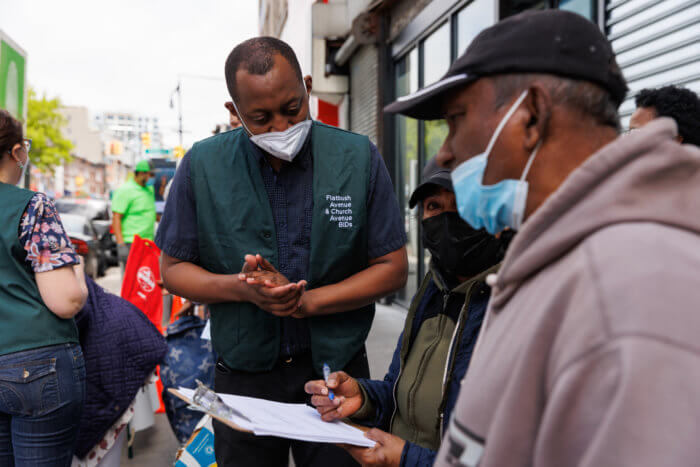 people speak to BID members at shredding event