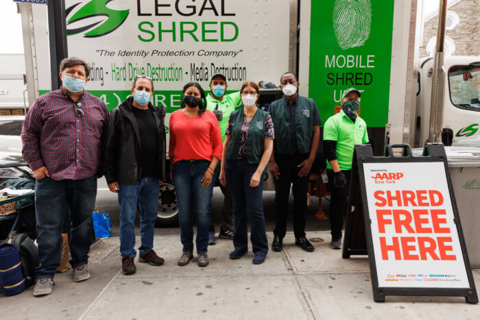 people stand in front of a shredding truck