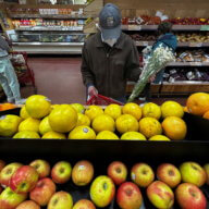 man looking at apples in grocery store. one in three brooklynites struggle with food insecurity