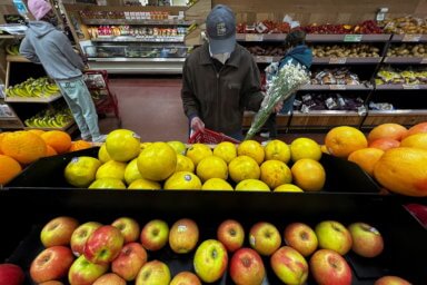 man looking at apples in grocery store. one in three brooklynites struggle with food insecurity