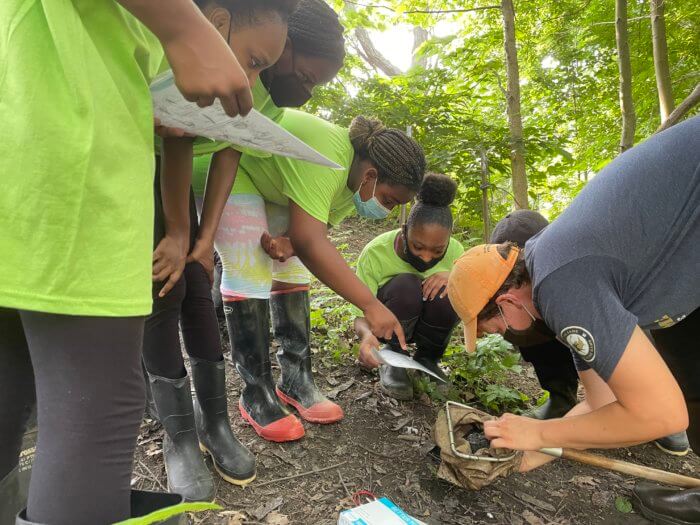 green girls examine an insect in a net