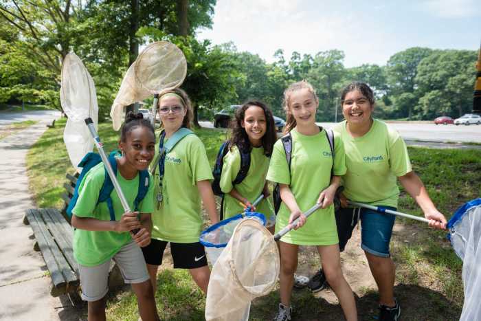 middle school girls in green tshirts with nets at green girls program