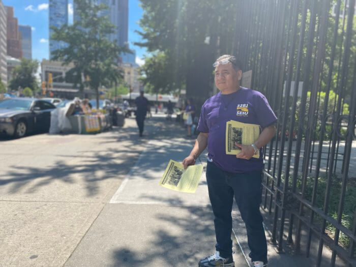 luis pacheco stands with fliers outside brooklyn law school