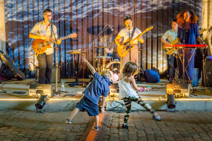 people dance in front of a band at live at the archway