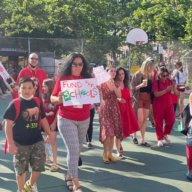 parents and students at rally for school budget cuts on basketball court