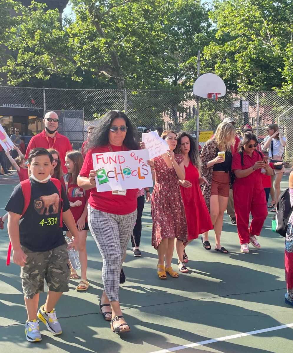 parents and students at rally for school budget cuts on basketball court