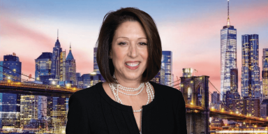 headshot of suri kasirer, a woman with short brown hair, smiling in front of the nyc skyline