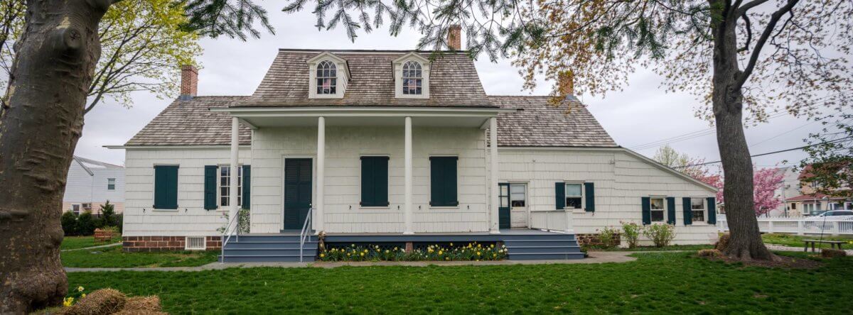 photo of lott house, with white siding and columns, hosting a taste of the neighborhood