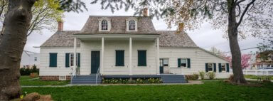 photo of lott house, with white siding and columns, hosting a taste of the neighborhood