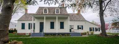 photo of lott house, with white siding and columns, hosting a taste of the neighborhood