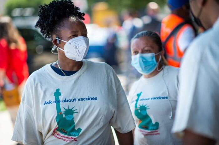 people wearing masks and t-shirts promoting the COVID-19 vaccine